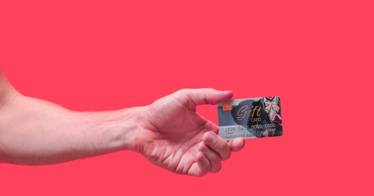 Hand holding gift card on red background